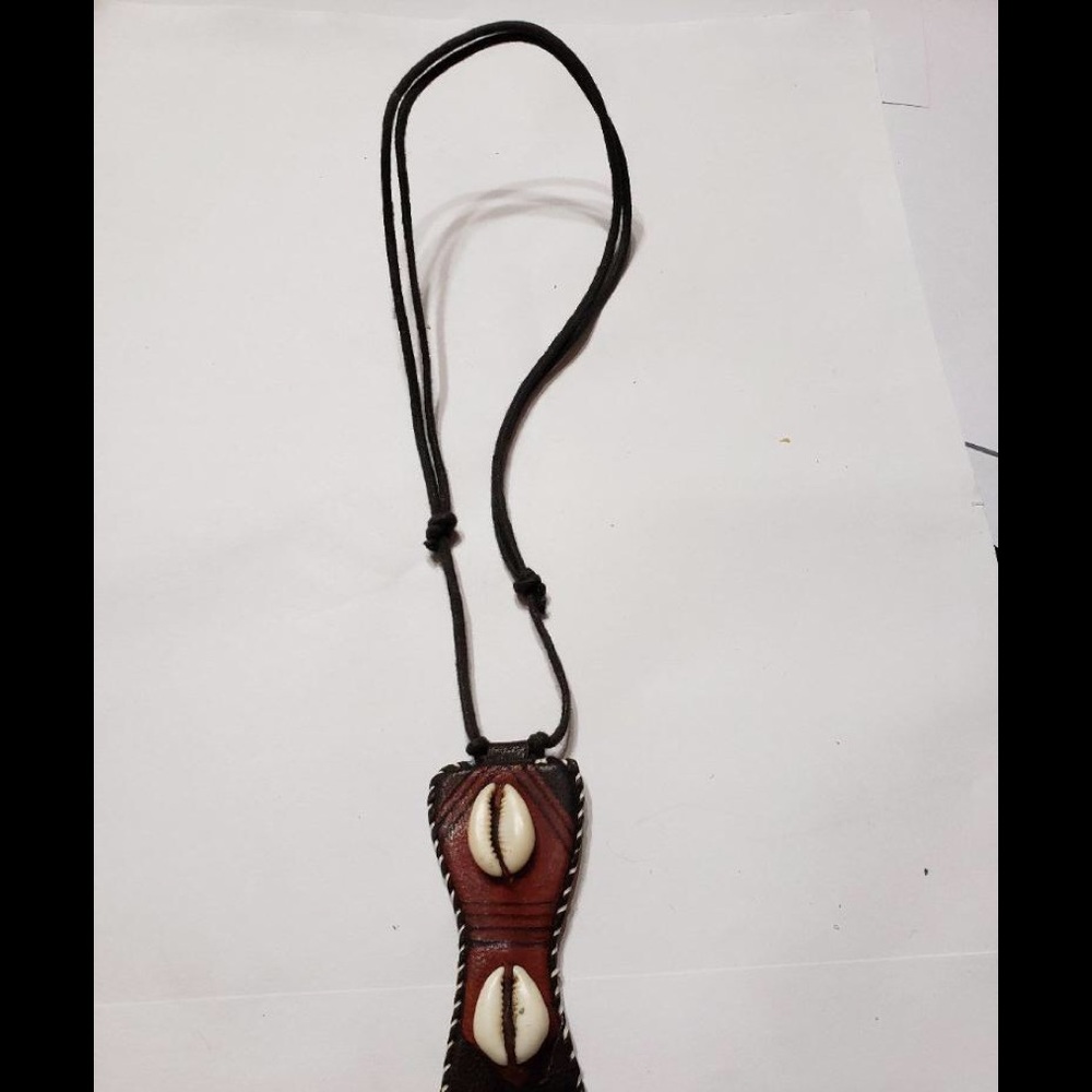Two cowrie shells on brown leather
